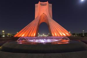 نمای شب برج آزادی تهران با نورپردازی نارنجی و آب‌نما جهت چاپ پوستر دیواری پذیرایی و دفاتر اداری