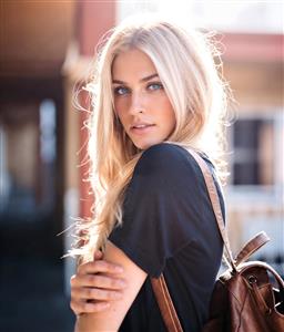 تصویر لایف استایل دختر بلوند با کوله پشتی در نور خورشید برای پوستر دیواری اتاق نوجوان و چاپ روی دفترچه