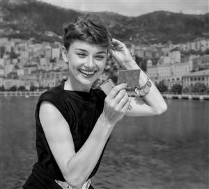 عکس سیاه و سفید لبخند آدری هپبورن هنرپیشه مشهور در ساحل ایده آل برای پوستر دیواری آرایشگاه و کافه مدرن