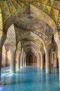 نمای داخلی مسجد با ستون‌های سنگی و نورهای رنگی مناسب پوستر دیواری سالن‌های بزرگ، لابی و فضاهای معنوی