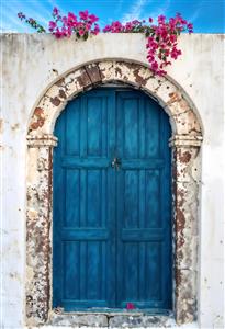 تصویر باکیفیت درب چوبی آبی کلاسیک با نمای دیوار سفید و گل‌های کاغذی مناسب چاپ تابلو شاسی و دیوارپوش کافه و آتلیه