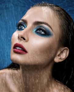 عکس باکیفیت چهره خیس زن زیر باران با سایه چشم آبی ایده‌آل برای پوستر دیواری ضدآب حمام و استخر