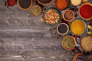 کادر بندی ادویه جات متنوع روی پس زمینه چوب تیره مناسب برای چاپ بنر، پوستر دیواری رستوران و رومیزی های چاپی