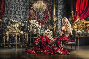 عکس حرفه‌ای مدل زن با لباس اشرافی قرمز در عمارت لوکس و دکوراسیون کلاسیک برای پوستر دیواری آتلیه و مزون لباس