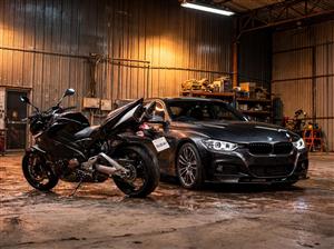 پوستر دیواری خودرو بی ام و مشکی و موتورسیکلت در فضای گاراژ صنعتی برای دکوراسیون نمایشگاه اتومبیل و باشگاه‌های ورزشی