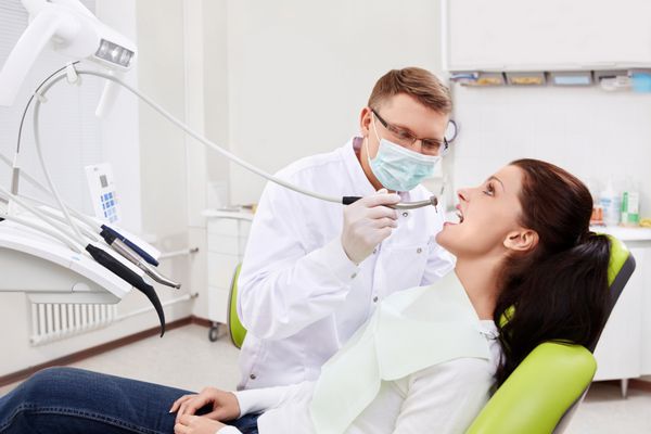 دندانپزشک دندان های بیمار را در کلینیک درمان می کند
