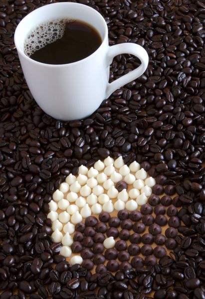 فنجان قهوه با چیپس های شکلات سفید و چیپس های شکلات شیری که نماد یین یانگ را تشکیل می دهند