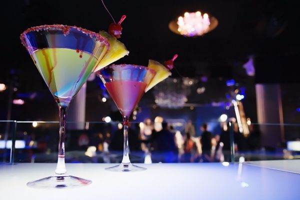 لیوان با کوکتل در کلوپ شبانه انواع مختلف نور DOF کم عمق