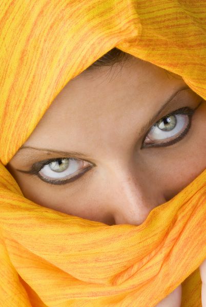 چشمان جذاب و قوی پشت روسری نارنجی که مانند برقع استفاده می شود