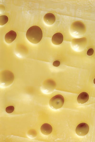 تصویر پس زمینه یک بلوک بزرگ پنیر سوئیسی Emmentaler