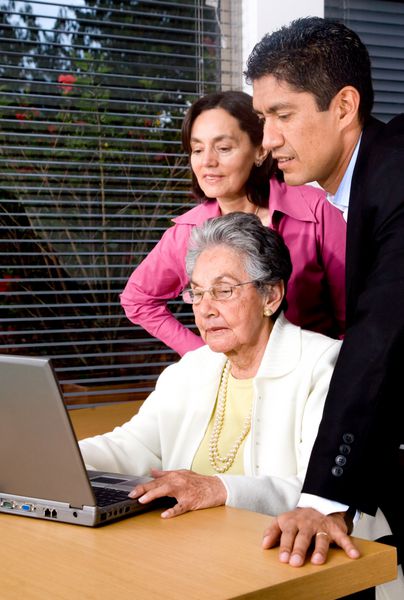خانواده روی لپ تاپ در حال لبخند زدن در خانه