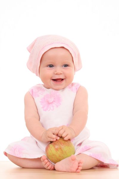دختر بچه 6 ماهه با سیب قرمز جدا شده روی سفید