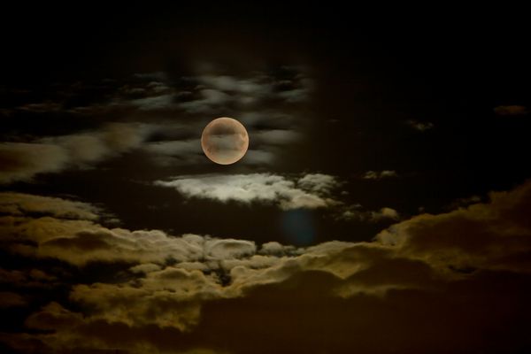تصویر ماه در آسمان ابری شب