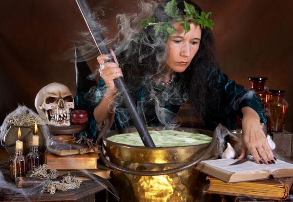 جادوگر هالووین در حال تکان دادن سوپ سم سبز در دیگ خود