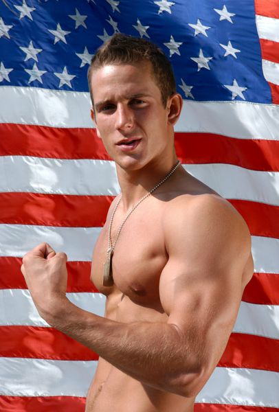 مرد جوان عضلانی با برچسب‌های ارتشی که عضله دوسر را خم کرده و پرچم ایالات متحده را پشت سر دارد