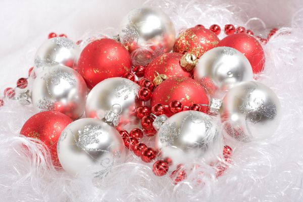 توپ های کریسمس سفید و قرمز و مهره های قرمز روی ریش بابانوئل