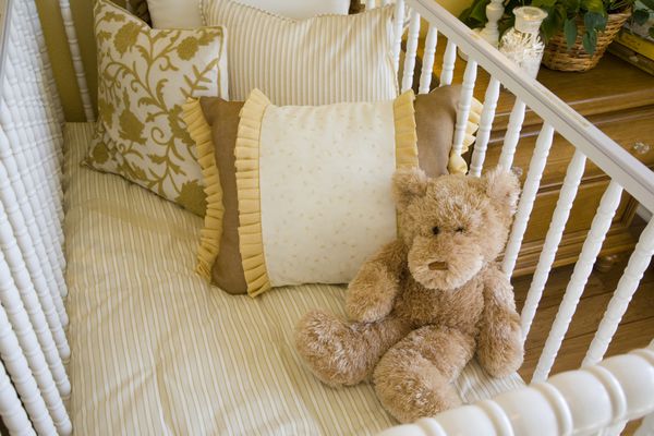 اتاق خواب کودک با تخت بالش و یک خرس عروسکی