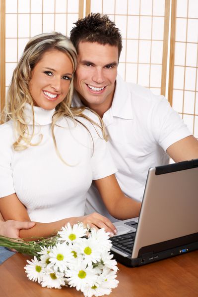 زوج عاشق جوان با لپ تاپ روی پس زمینه سفید