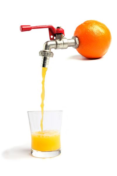 آب پرتقال تازه از پرتقال در یک لیوان ریخته می شود