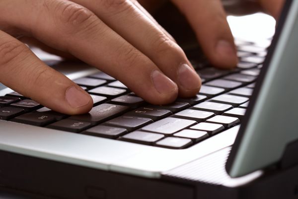 انگشتان روی صفحه کلید لپ تاپ