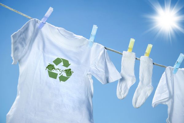 تی شرت با آرم بازیافت که در یک روز گرم تابستان روی بند رخت خشک می شود