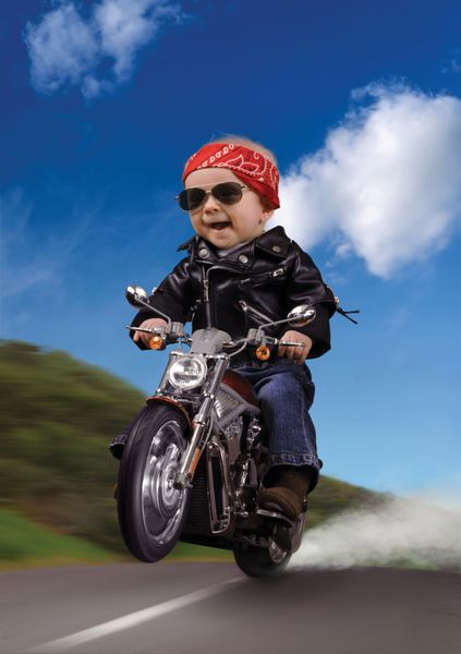 کودکی که لباس دوچرخه سواری پوشیده است و چرخی سوار بر موتور سیکلت می زند