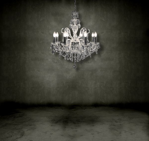 لوستر کریستالی آویزان در اتاقی تاریک و تیره