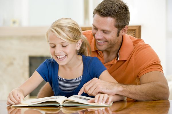 مرد و دختر جوان در حال خواندن کتاب در اتاق غذاخوری با لبخند