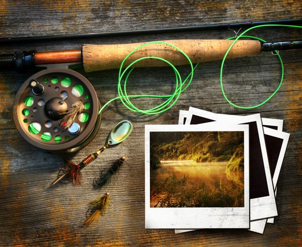 میله ماهیگیری فلای با تصاویر عکس فوری در پس زمینه چوبی