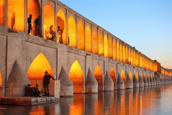 پل خواجو بر روی زاینده رود در غروب با چراغ اصفهان ایران
