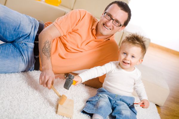 پدر و پسر کوچک در حال بازی ساخت و ساز با هم در خانه