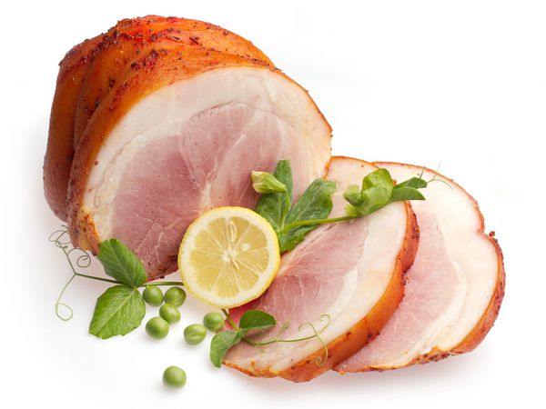گوشت خوک آب پز سرد تزئین شده با لیمو و نخود سبز روی زمینه سفید
