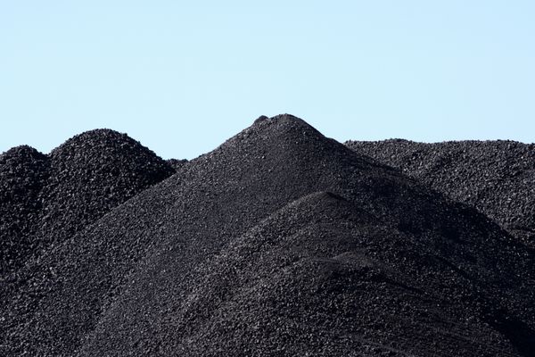 کوه های سیاه از قطعات زغال سنگ که برای حمل و نقل ذخیره می شوند