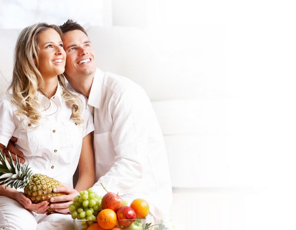زوج عاشق جوان با میوه ها در آپارتمان راحت