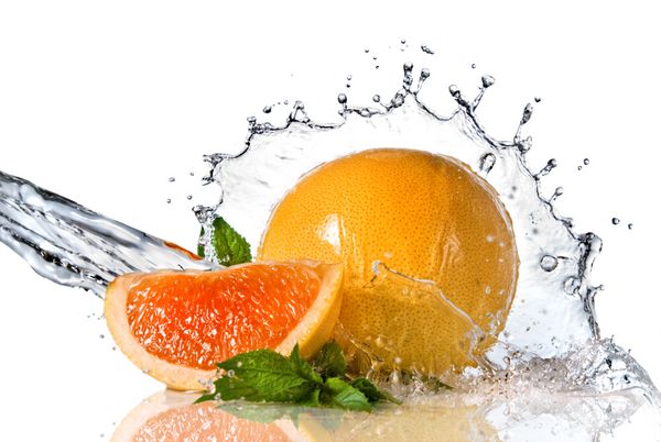 پاشیدن آب روی پرتقال با نعناع جدا شده روی سفید