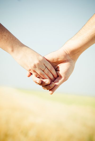نمای نزدیک دست در دست با حلقه ازدواج