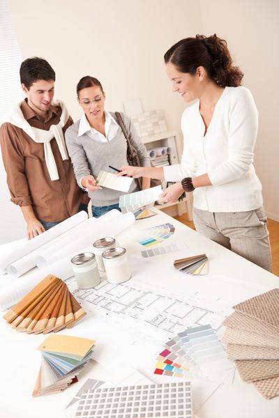 طراح داخلی زن با دو مشتری در دفتر انتخاب رنگ