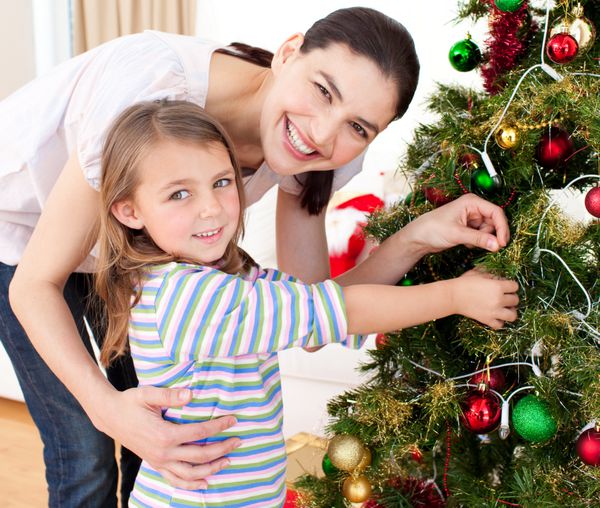مادر شاد و دخترش در حال تزئین درخت کریسمس