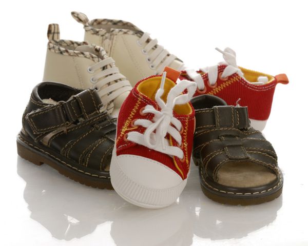 انبوهی از کفش های نوزاد یا نوزاد با انعکاس در زمینه سفید