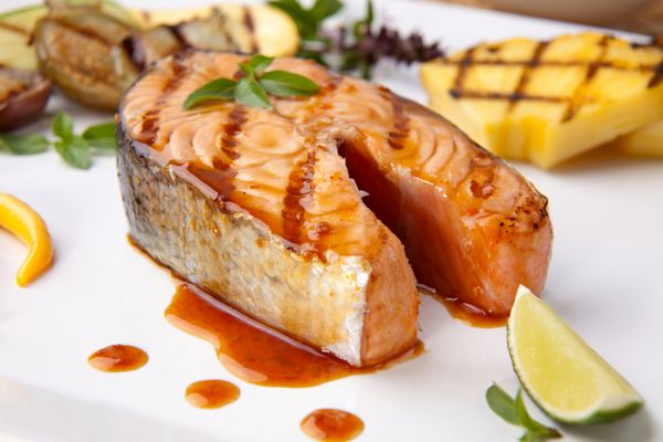 استیک ماهی سالمون کبابی خوشمزه Teriyaki با آناناس کبابی بادمجان بچه کدو سبز و فلفل چیلی برای یک شام سالم تزئین شده است