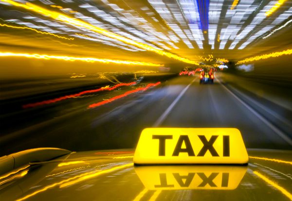 رانندگی تاکسی با سرعت زیاد از طریق ترافیک سنگین در شب از سقف کابین دیده می شود