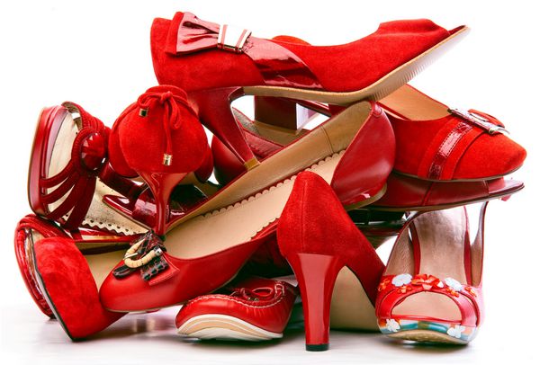انبوهی از کفش های قرمز زنانه جدا شده در پس زمینه سفید