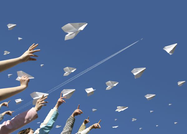 دست های بچه ها به شیوه هواپیماهای کاغذی پیام ها را به سمت بالا پرتاب می کند