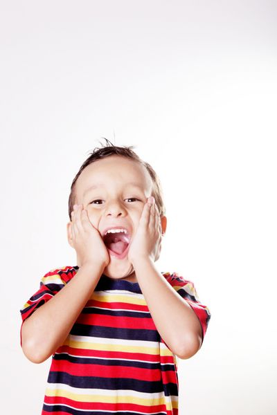 کودک در حال ابراز تعجب و خوشحالی با دستانش در صورتش