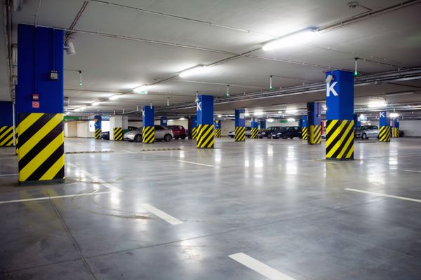 پارکینگ داخلی زیرزمینی با چند ماشین پارک شده نور نئون در ساختمان صنعتی روشن