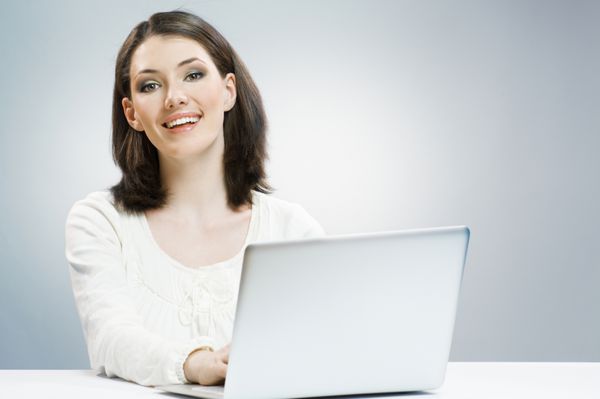 یک زن زیبا که در لپ تاپ کار می کند