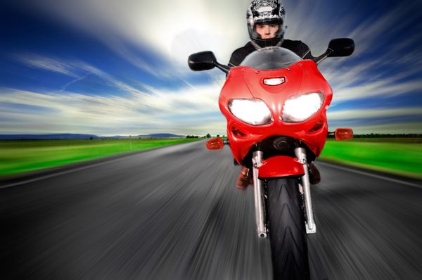 موتورسیکلت با حرکت بسیار سریع در امتداد جاده تار حرکت می کند