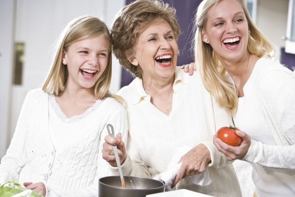مادربزرگ با خانواده در حال آشپزی در آشپزخانه لبخند زدن و خندیدن با هم