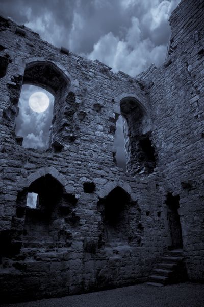 یک قلعه بسیار شبح وار در زیر نور ماه ماه از پنجره می درخشد