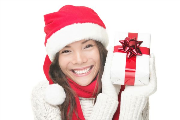 زن بابانوئل در حال نشان دادن هدیه با کلاه بابانوئل پرتره زن کریسمس از یک آسیایی ناز و خندان زیبا